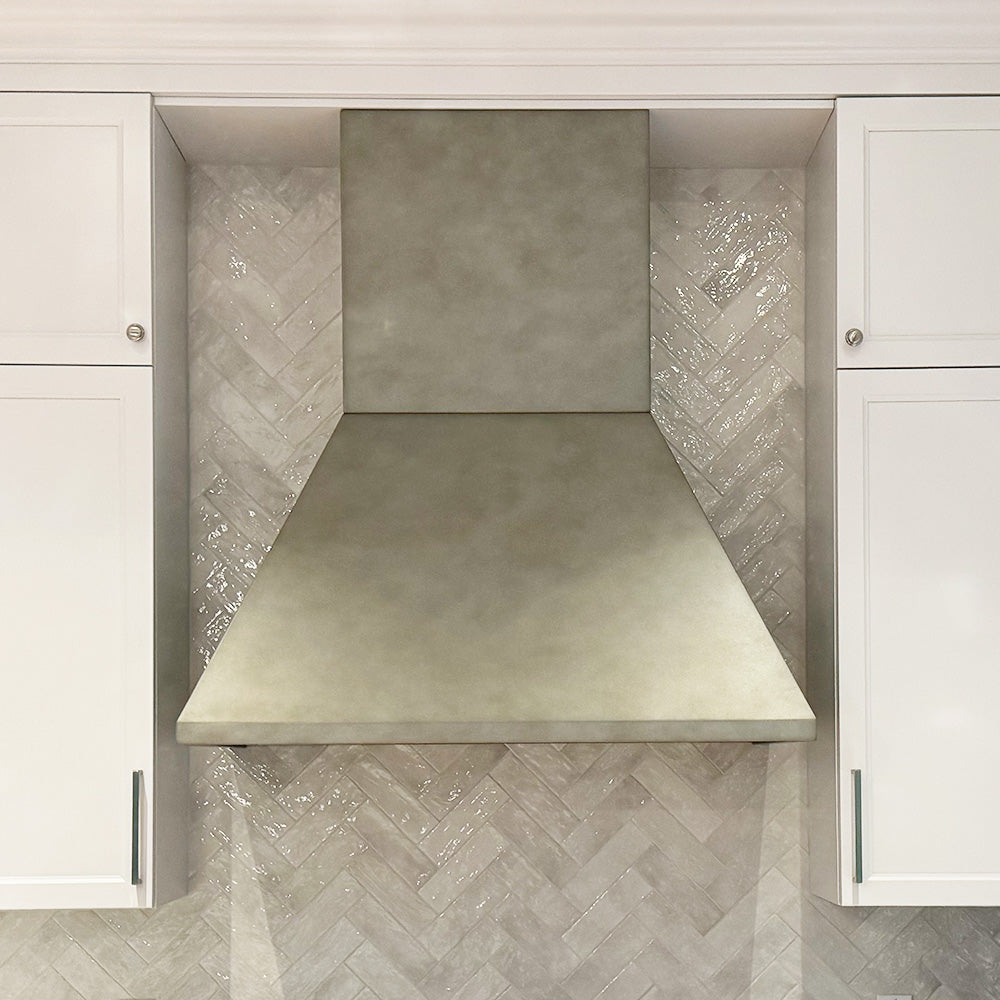 antique zinc modern range hood on herringbone tile backsplash