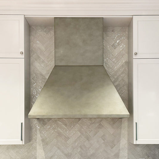 antique zinc modern range hood on herringbone tile backsplash