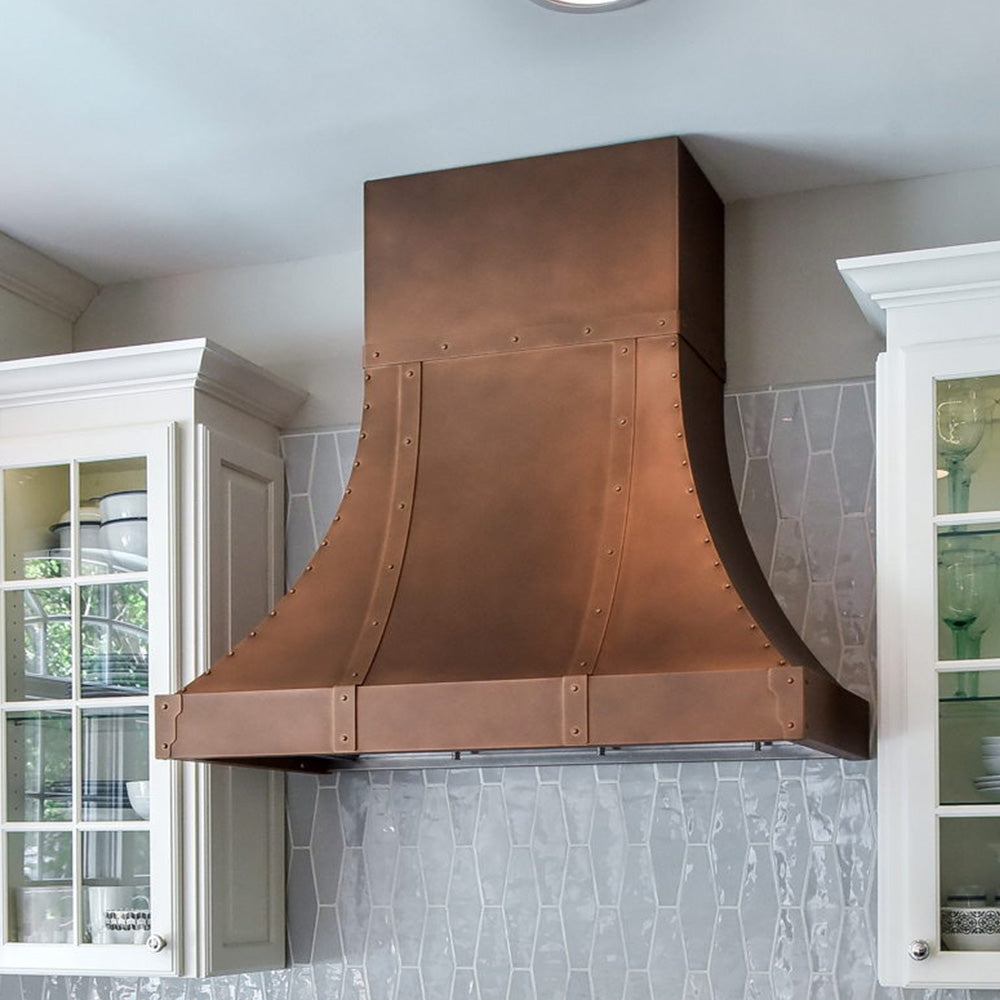 sweep copper range hood with white cabinets